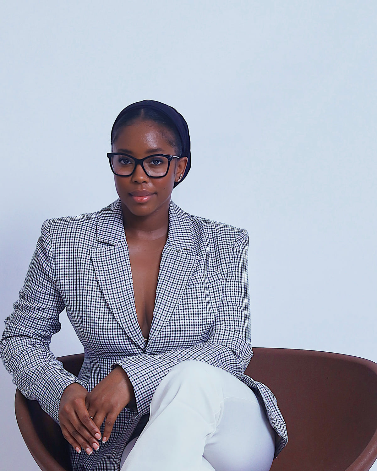 Sohna Oulare seated in a gray checked blazer